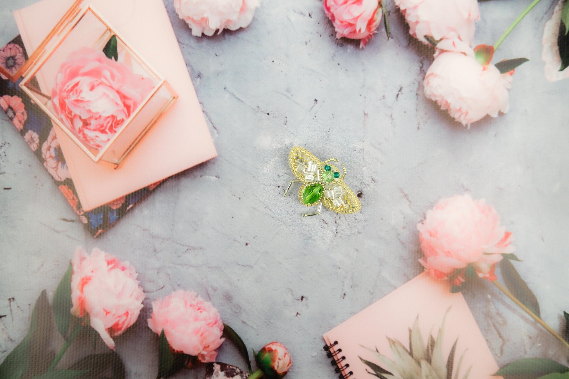 a yellow butterfly sitting on top of a table next to pink flowers