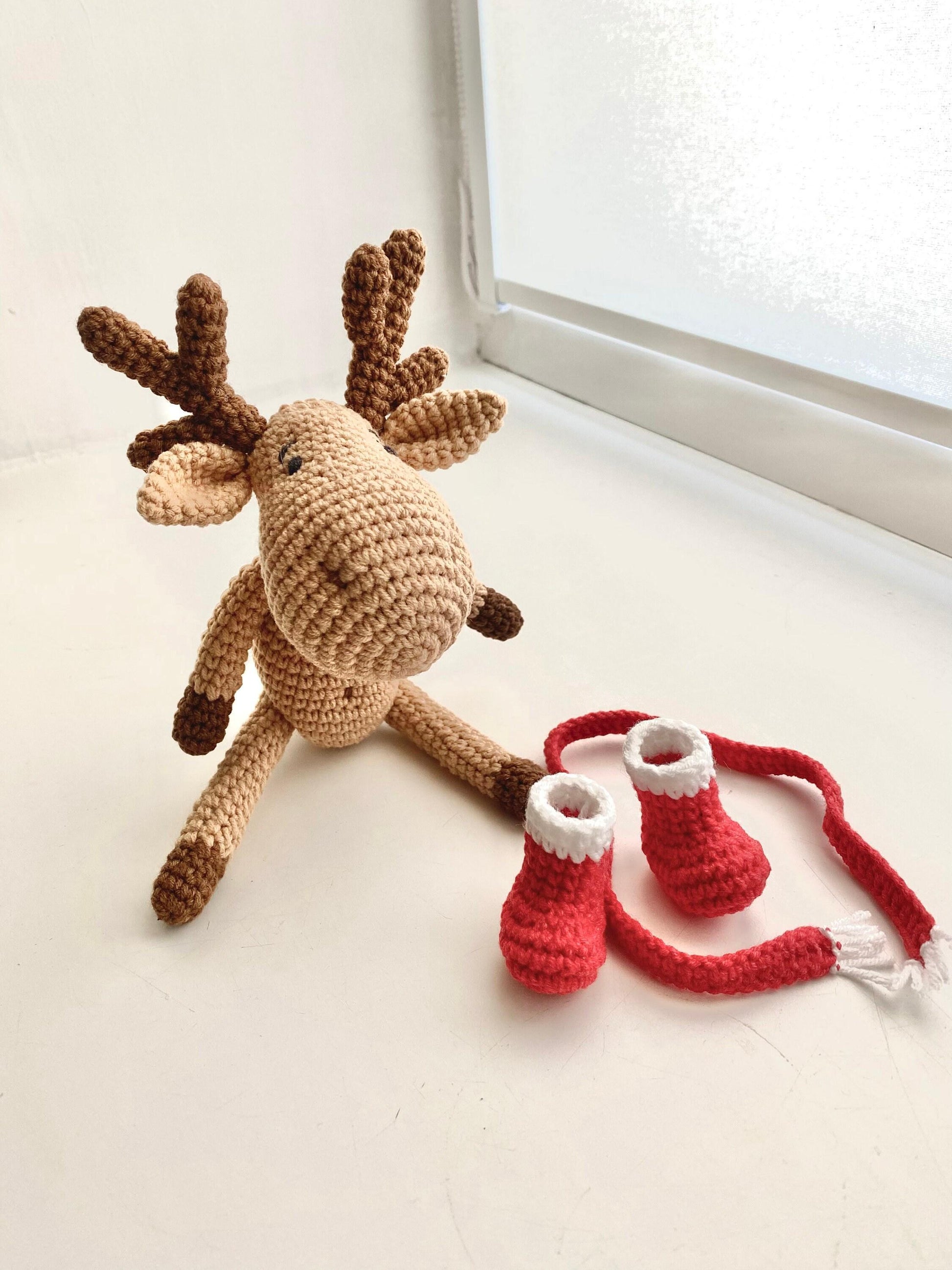 a crocheted stuffed animal next to a pair of knitted slippers