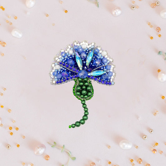 a brooch with a blue flower on it
