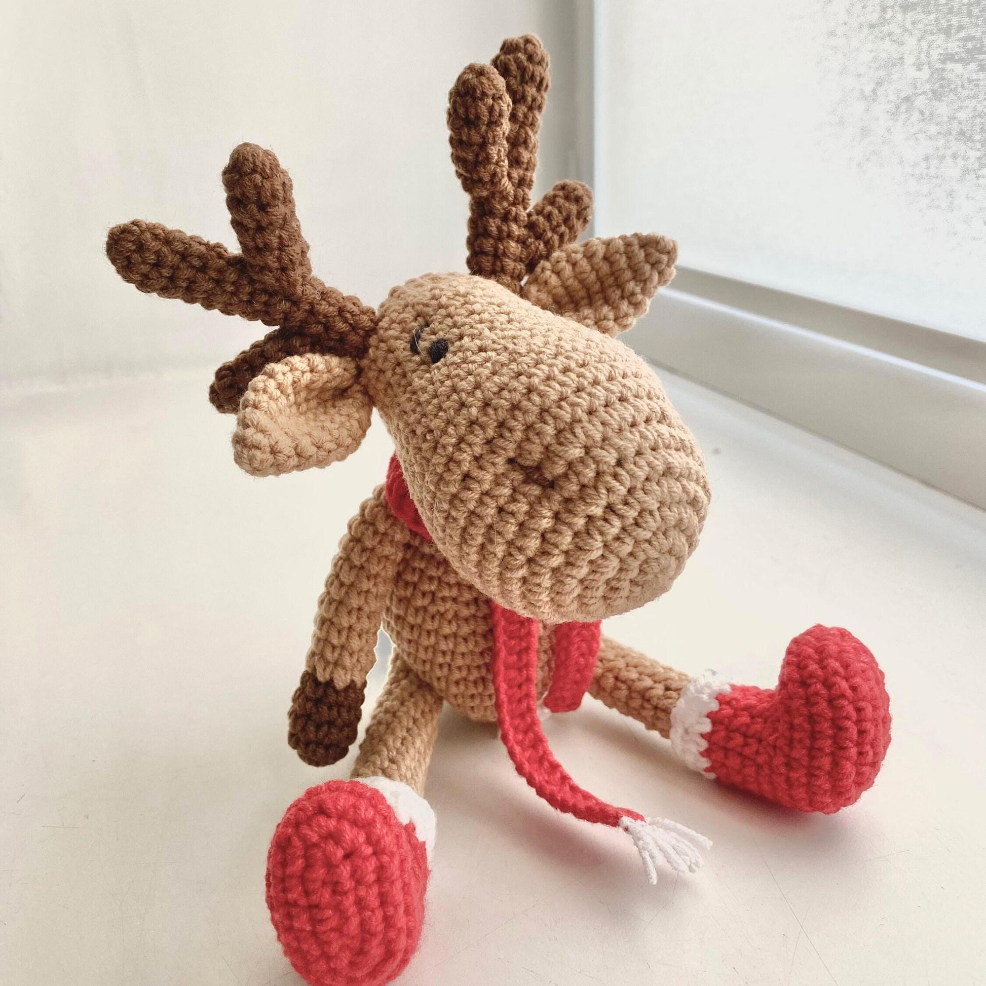 a crocheted stuffed animal sitting on a window sill