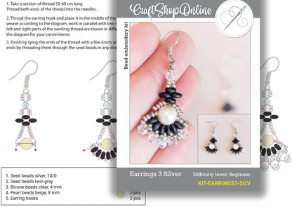 a picture of a hand holding a pair of earrings