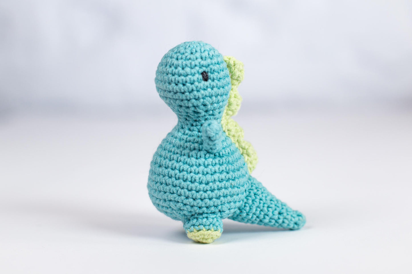 a crocheted toy of a blue dinosaur