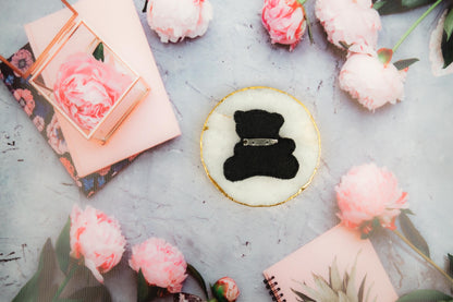 a black teddy bear sitting on top of a table
