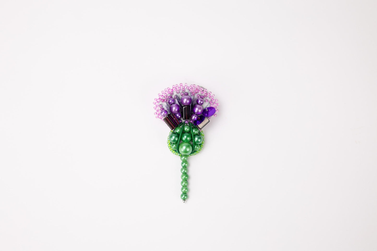 a green and purple flower on a white background
