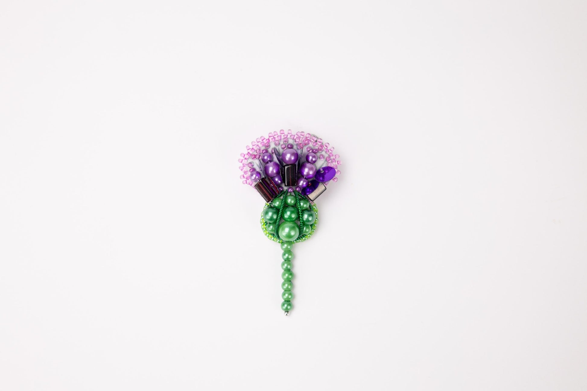 a green and purple flower on a white background
