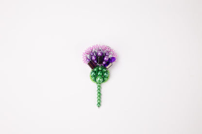 a green and purple flower on a white background