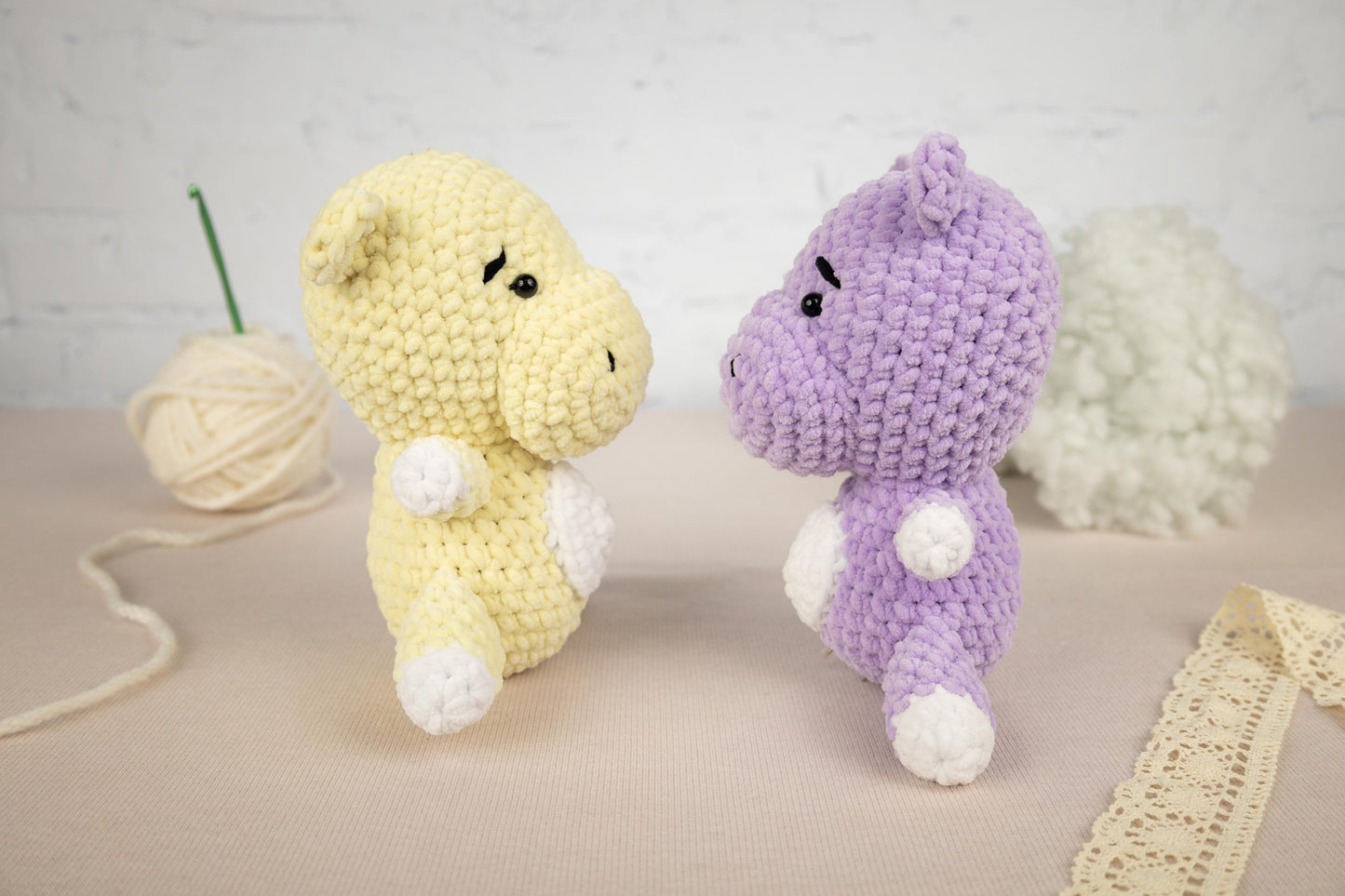 a couple of stuffed animals sitting next to a ball of yarn