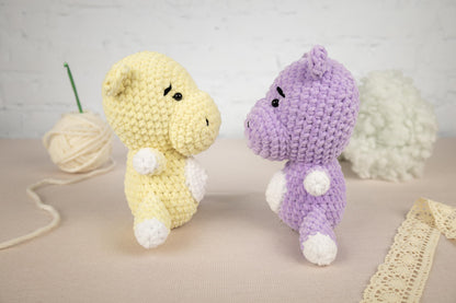 a couple of stuffed animals sitting next to a ball of yarn