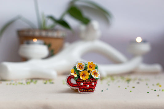 a small cup with flowers in it sitting on a table