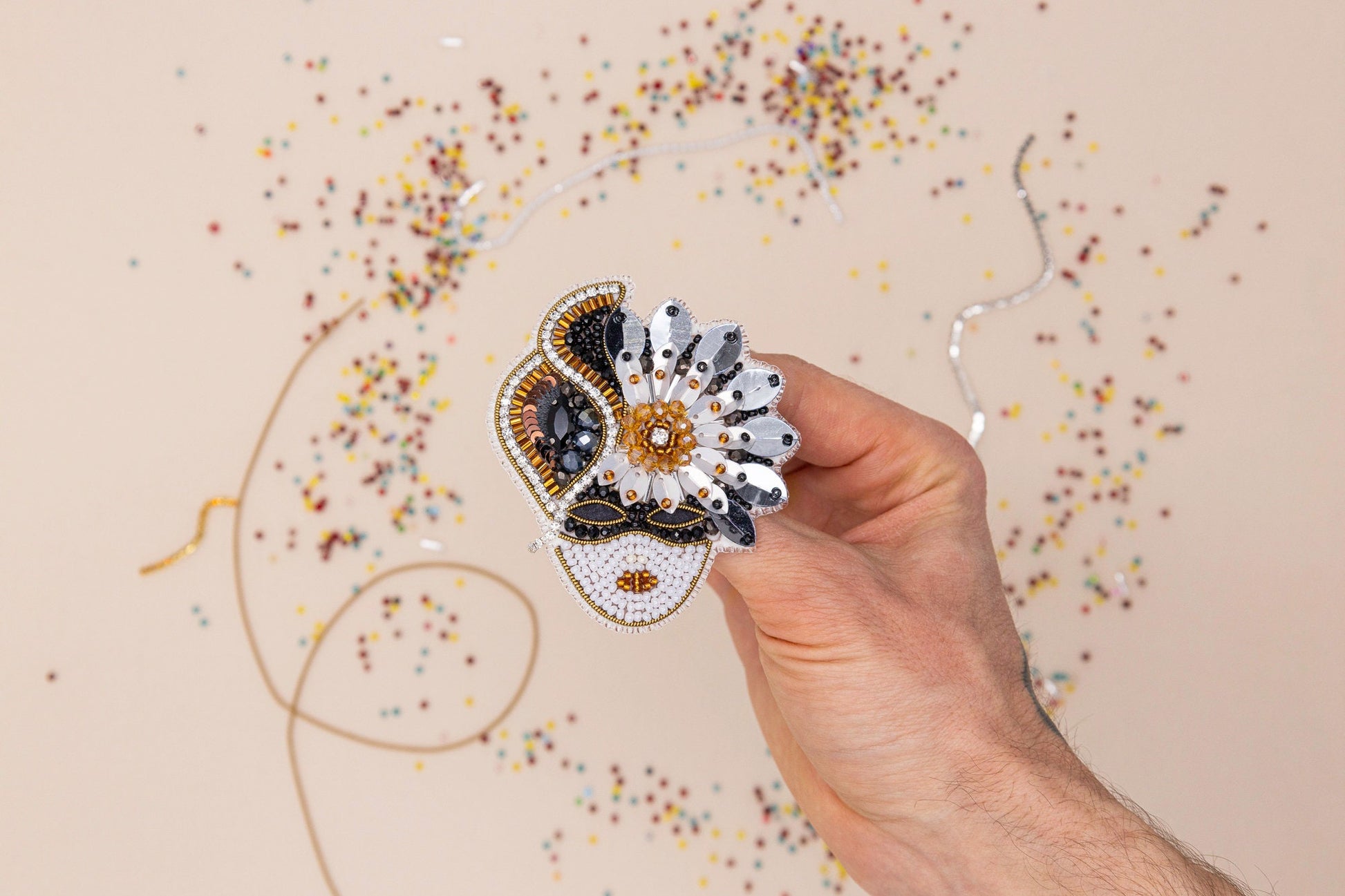 a hand holding a piece of paper with a flower on it