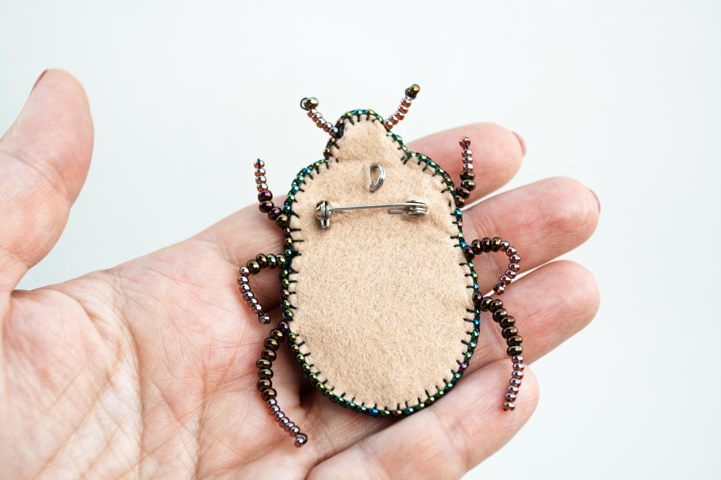 a person holding a small bug in their hand