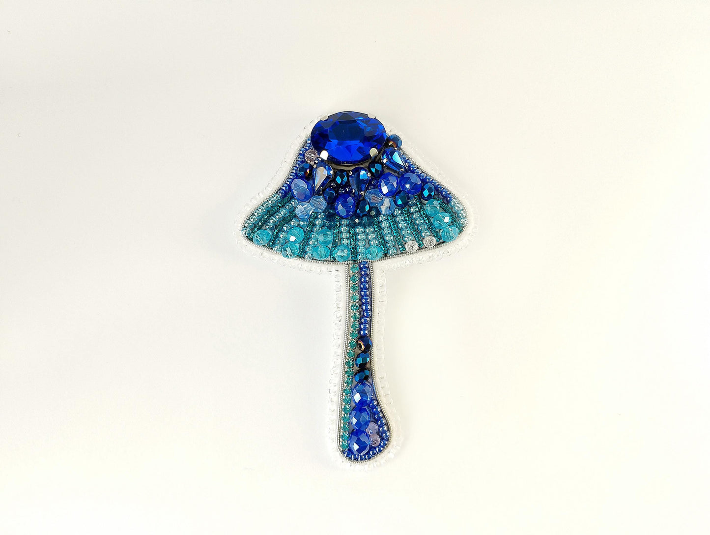 a brooch with a blue beaded design on it