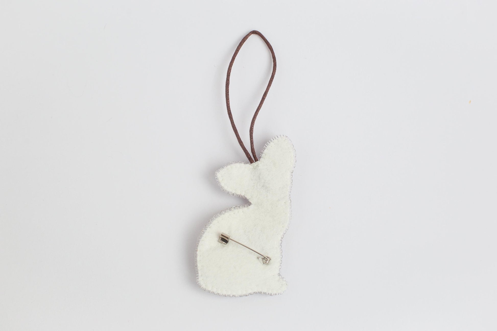 a white ornament hanging from a brown cord