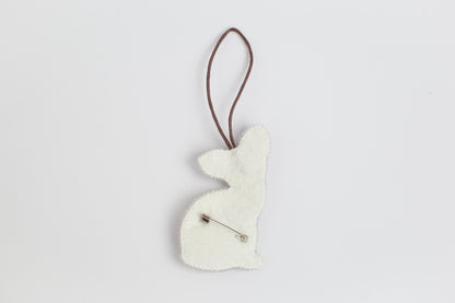 a white ornament hanging from a brown cord