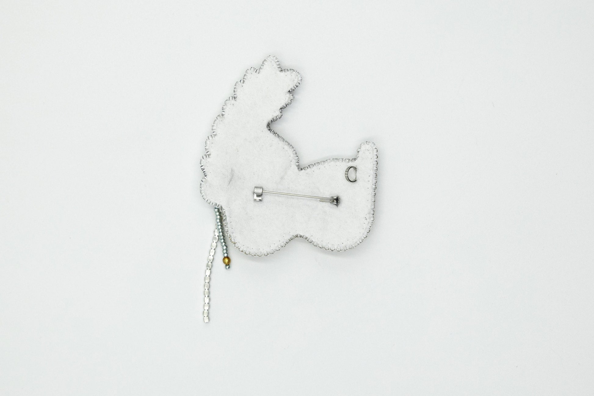 a white brooch with a white bear on it