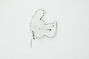 a white brooch with a white bear on it
