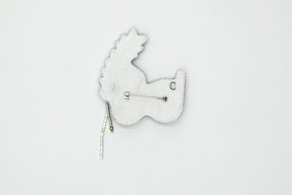 a white brooch with a white bear on it