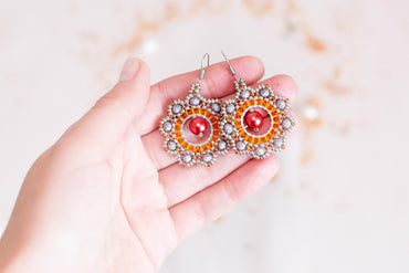 a person holding a pair of earrings in their hand