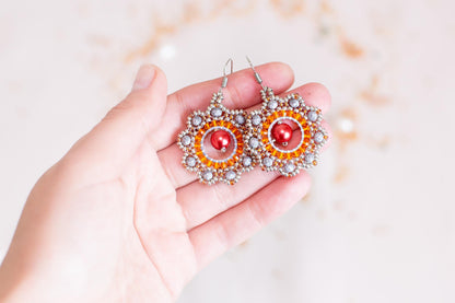 a person holding a pair of earrings in their hand