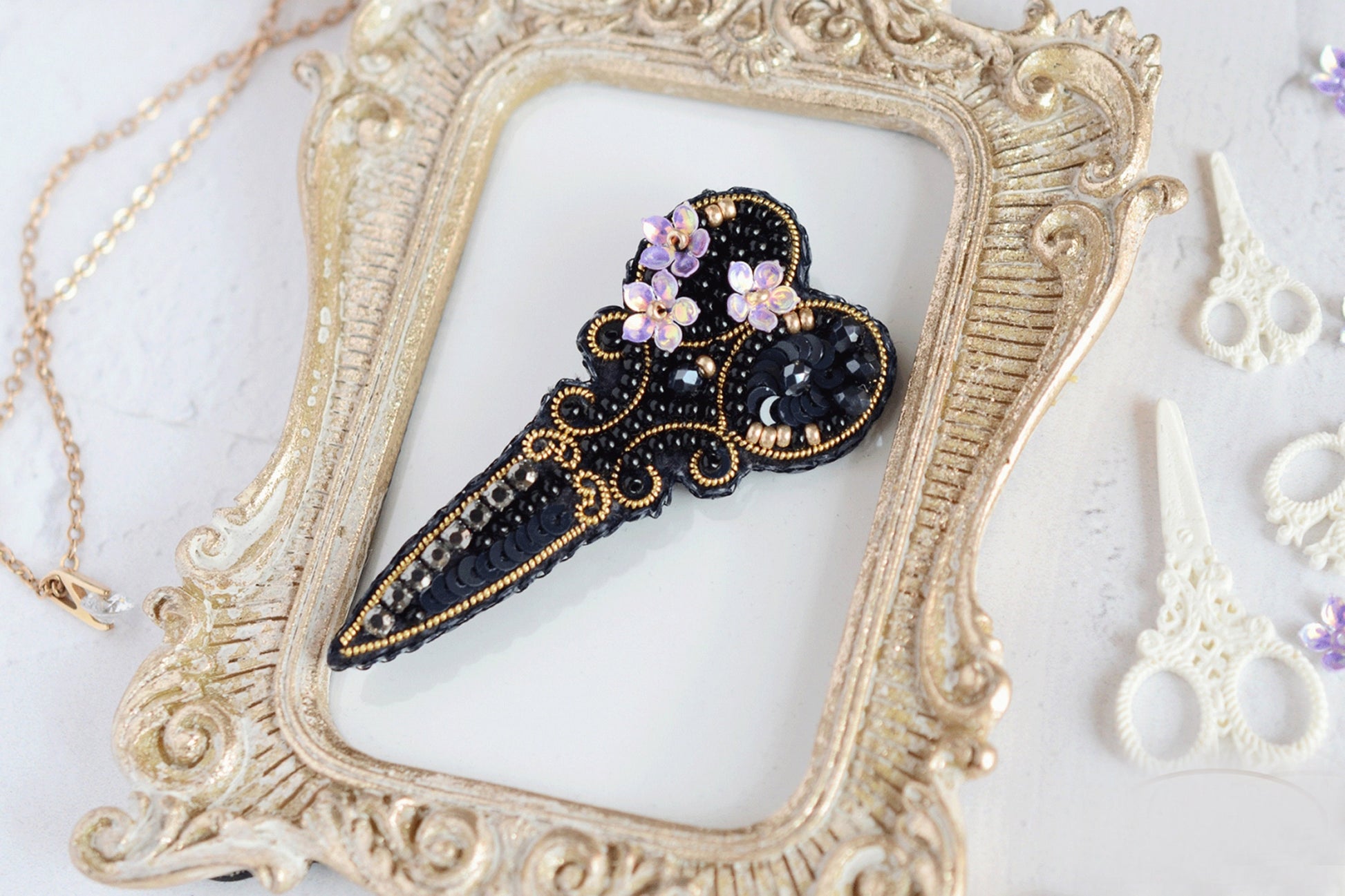 a picture frame with a black and gold brooch