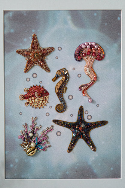 a collection of six decorative sea-themed objects, including a starfish, a jellyfish, a seahorse, a pearlfish, a star, and a coral.