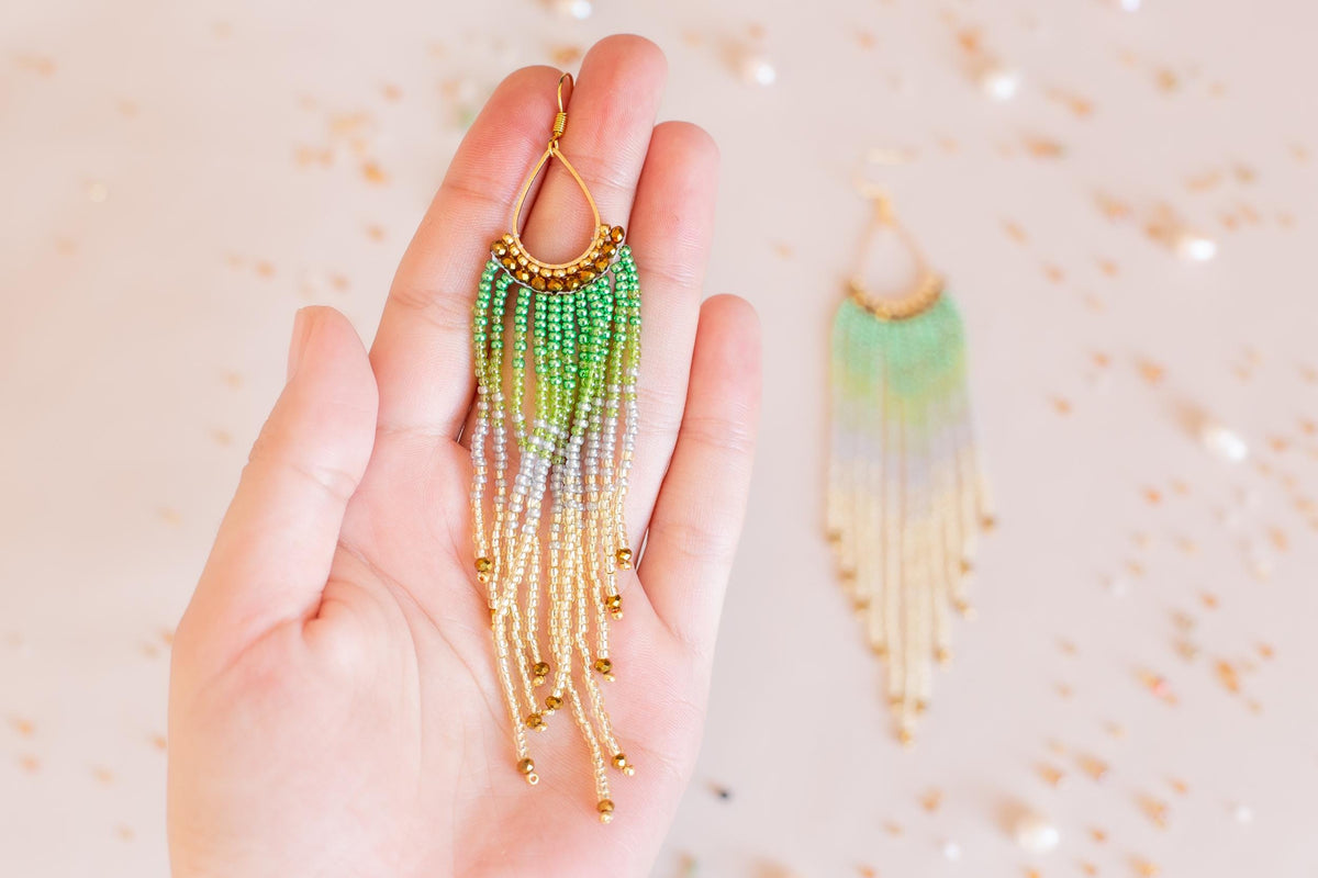 a person holding a pair of earrings in their hand