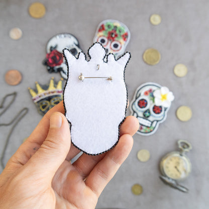 a person holding a pin with a cat on it