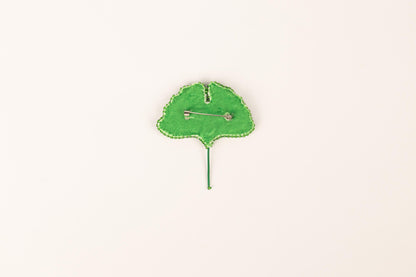 a green leaf shaped clock on a white surface