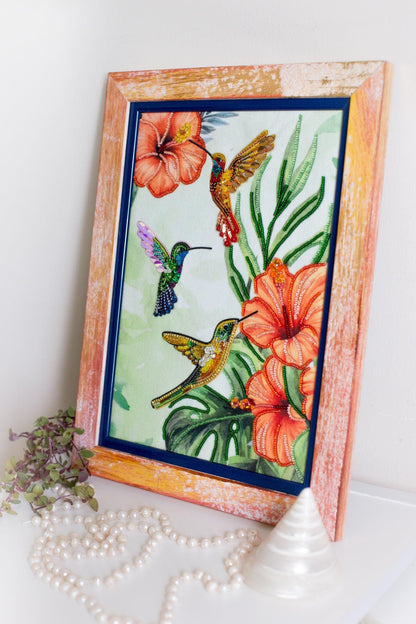 a picture frame with a painting of a hummingbird and flowers