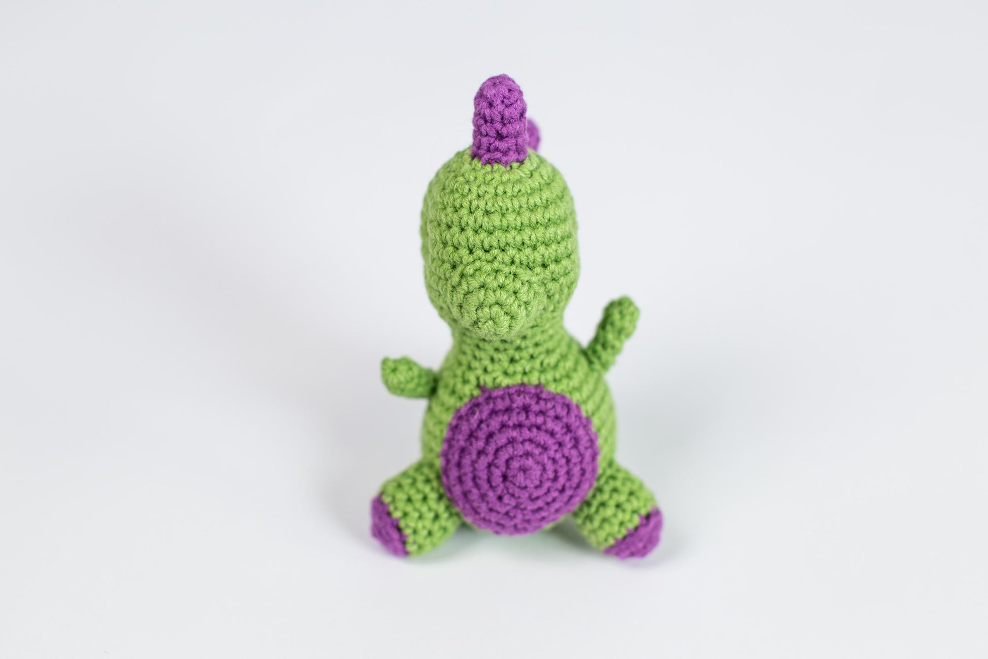 a crocheted green and purple stuffed animal