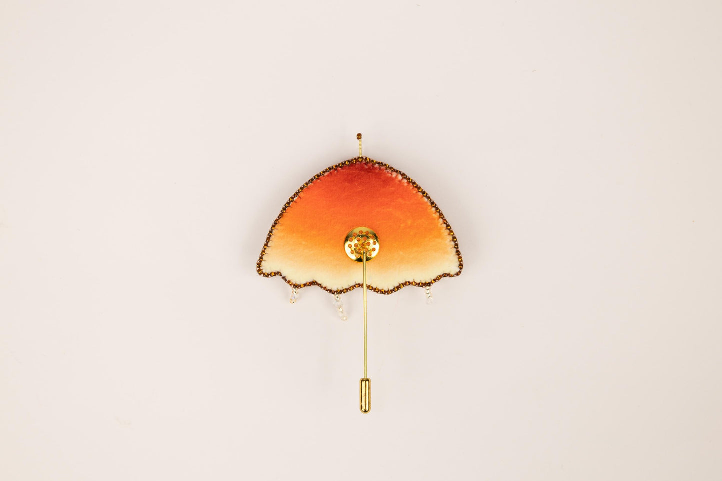 an orange and yellow clock on a white wall