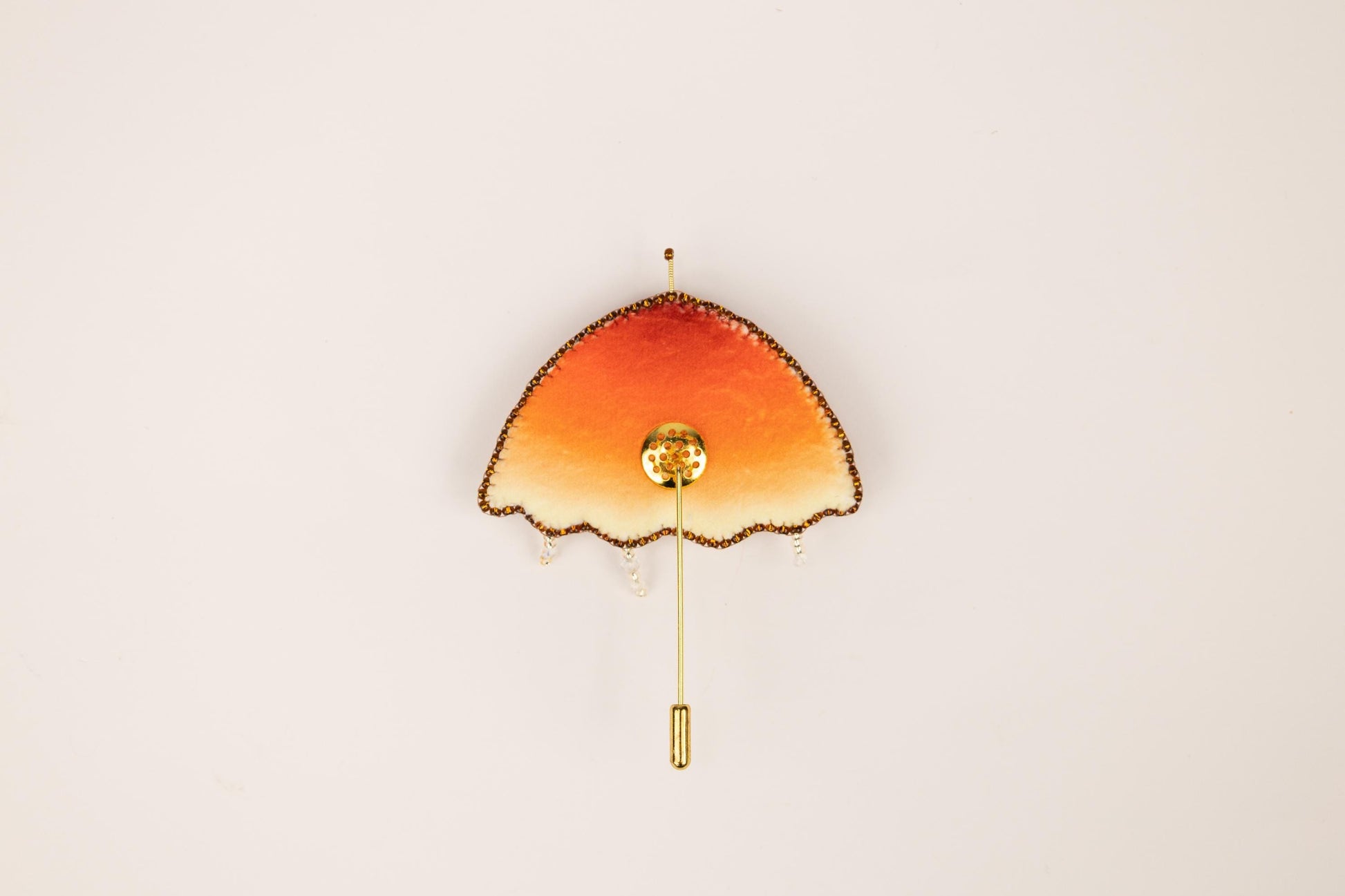 an orange and yellow clock on a white wall