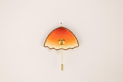 an orange and yellow clock on a white wall