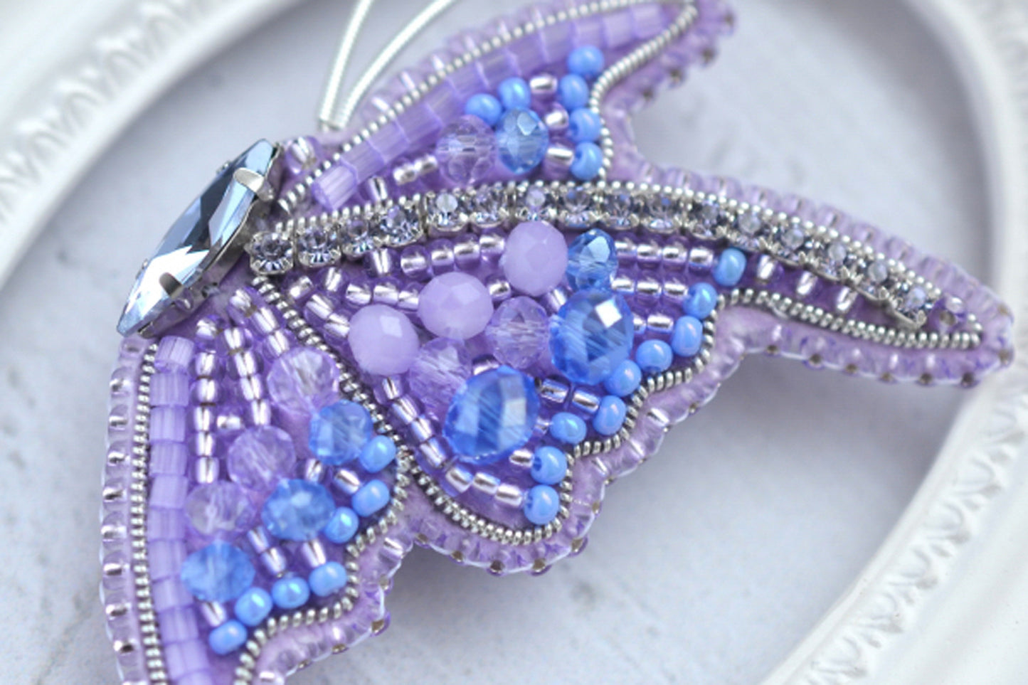 a close up of a beaded butterfly on a plate
