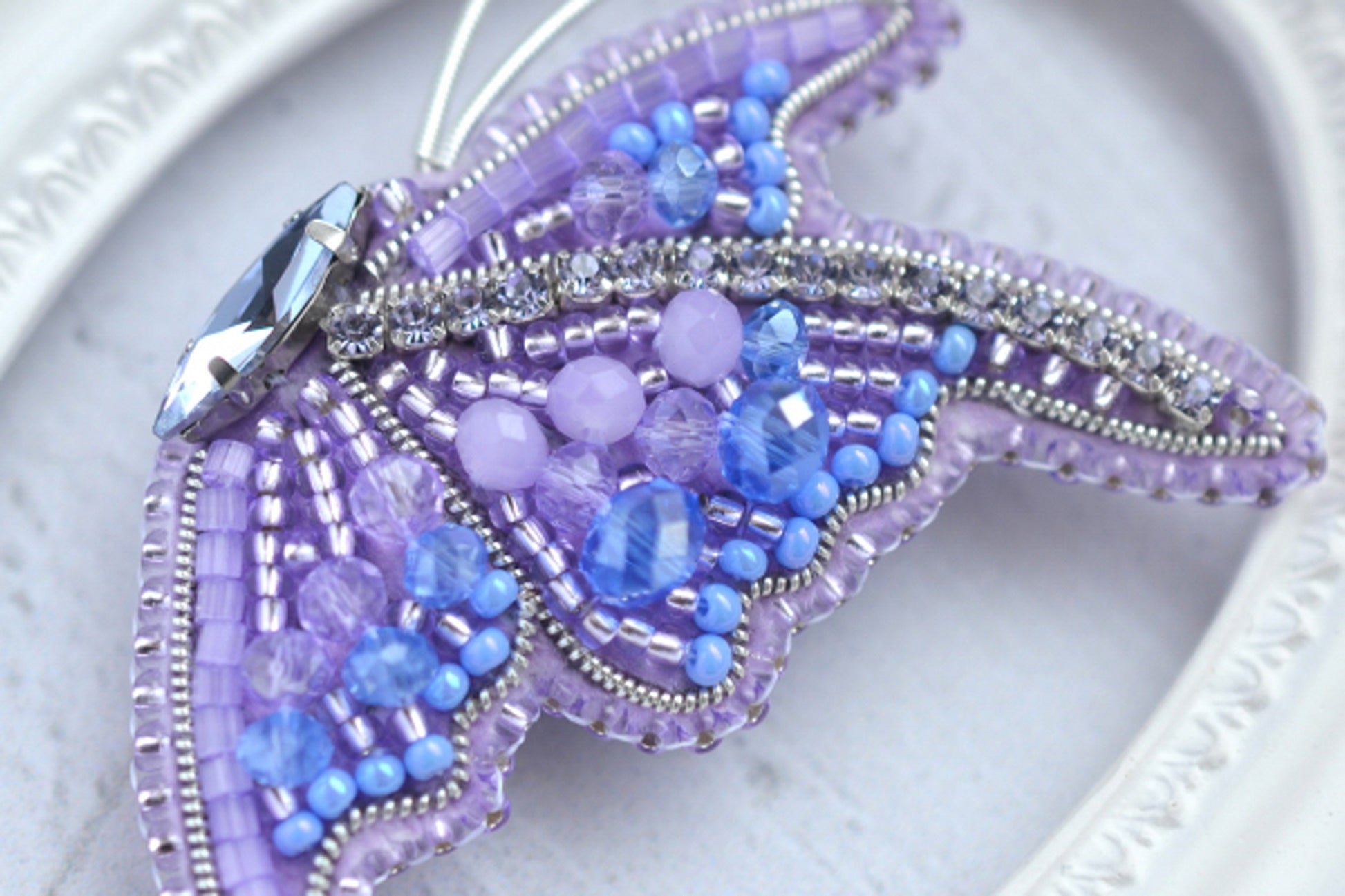 a close up of a beaded butterfly on a plate