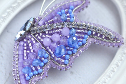 a close up of a beaded butterfly on a plate