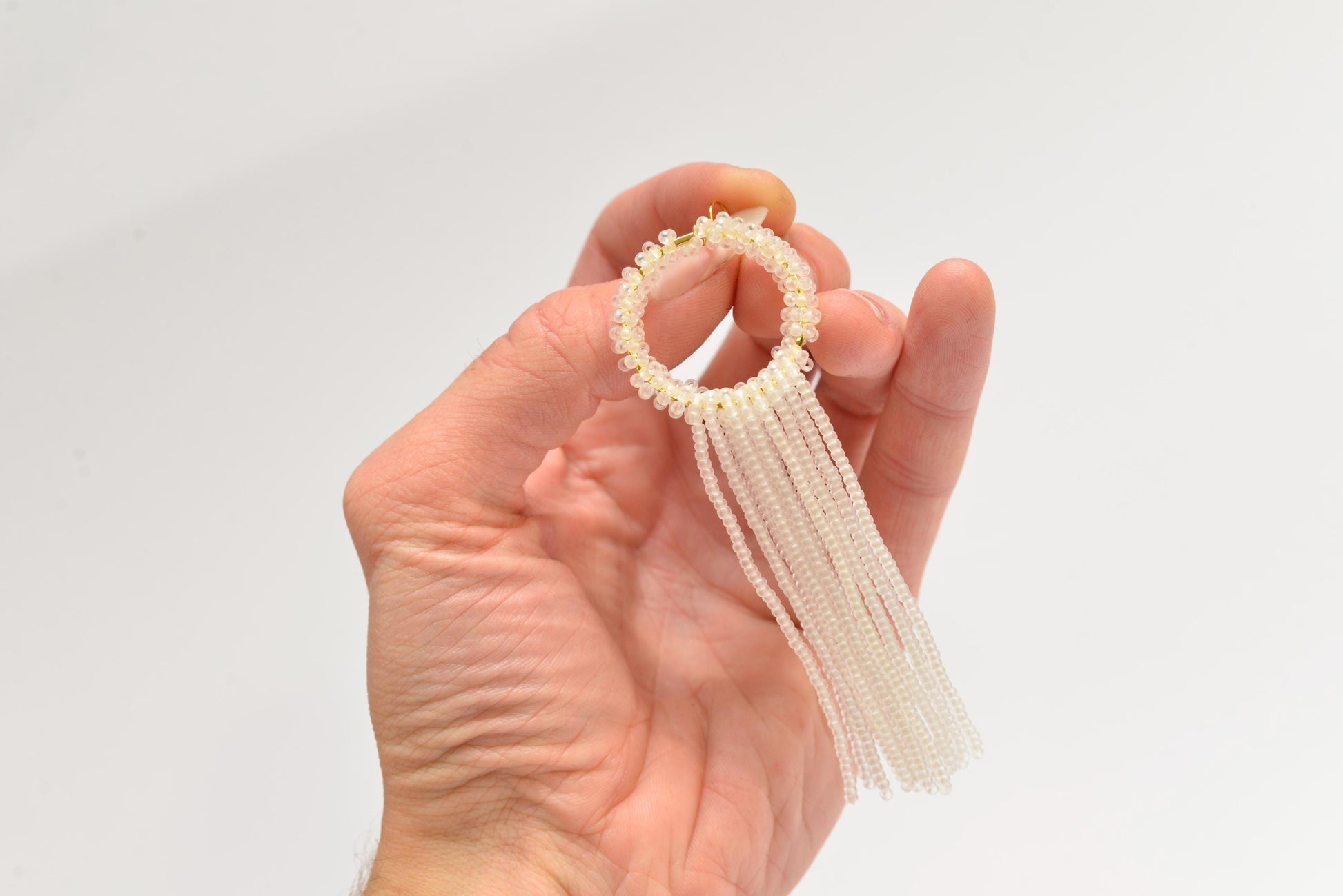 a hand holding a piece of jewelry in it&#39;s palm