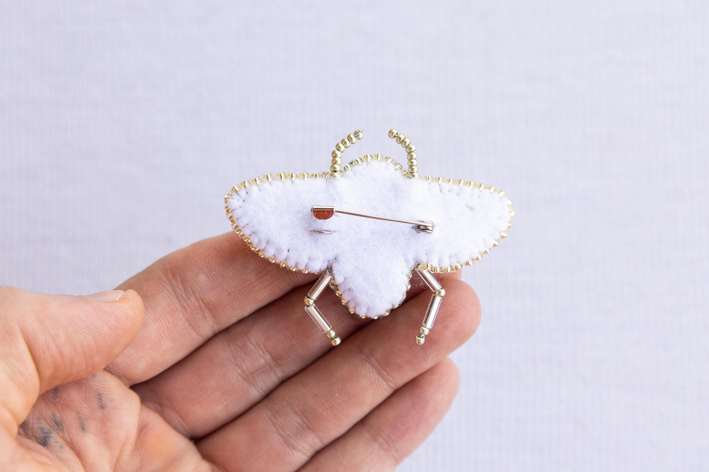 a person holding a pin with a heart on it