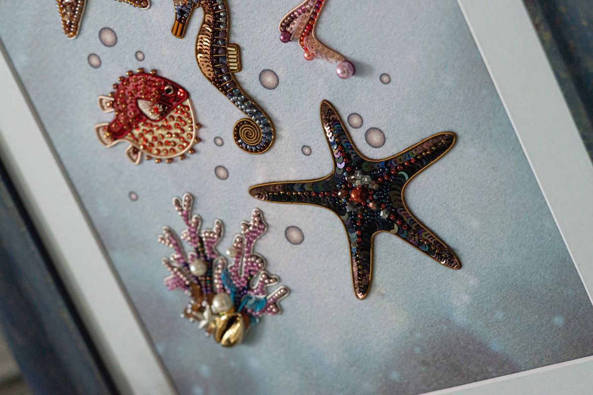 a close-up view of a framed collage of various marine life, including a starfish, a fish, and a coral.