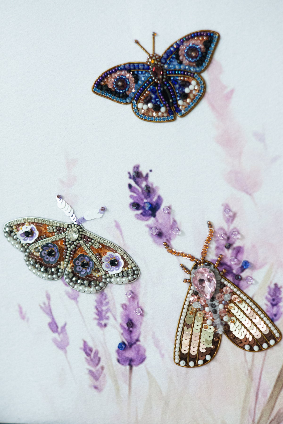 three intricately designed butterflies, each with unique patterns and colors, set against a backdrop of purple flowers.