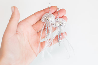 a person holding a pair of earrings in their hand