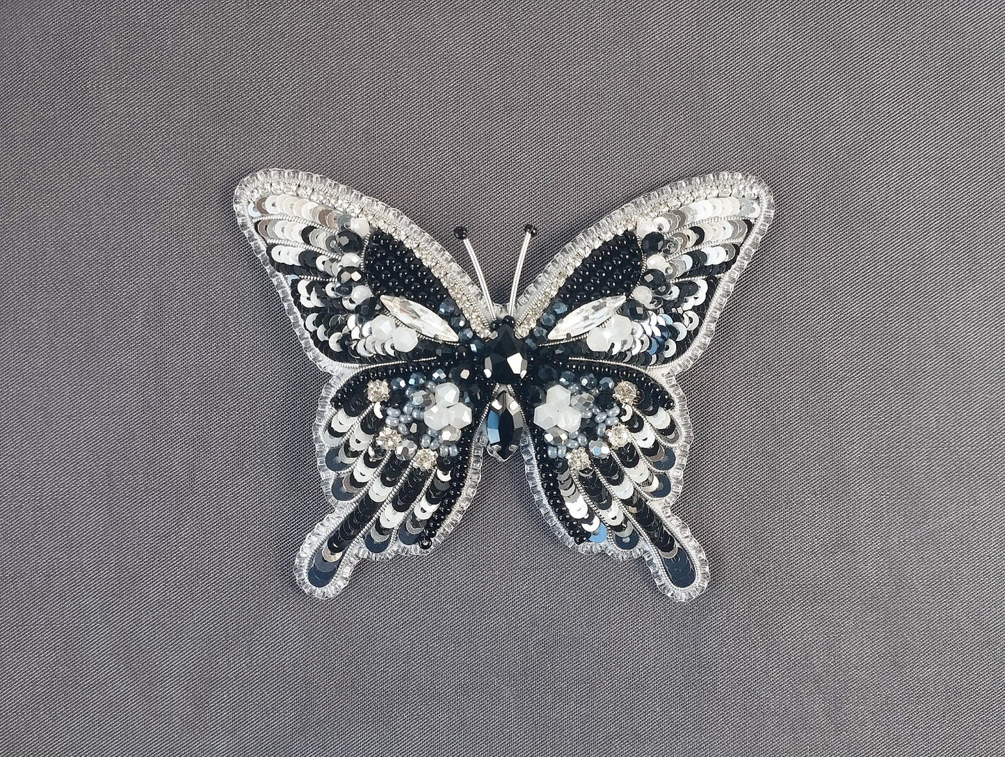 a black and white butterfly brooch sitting on top of a table