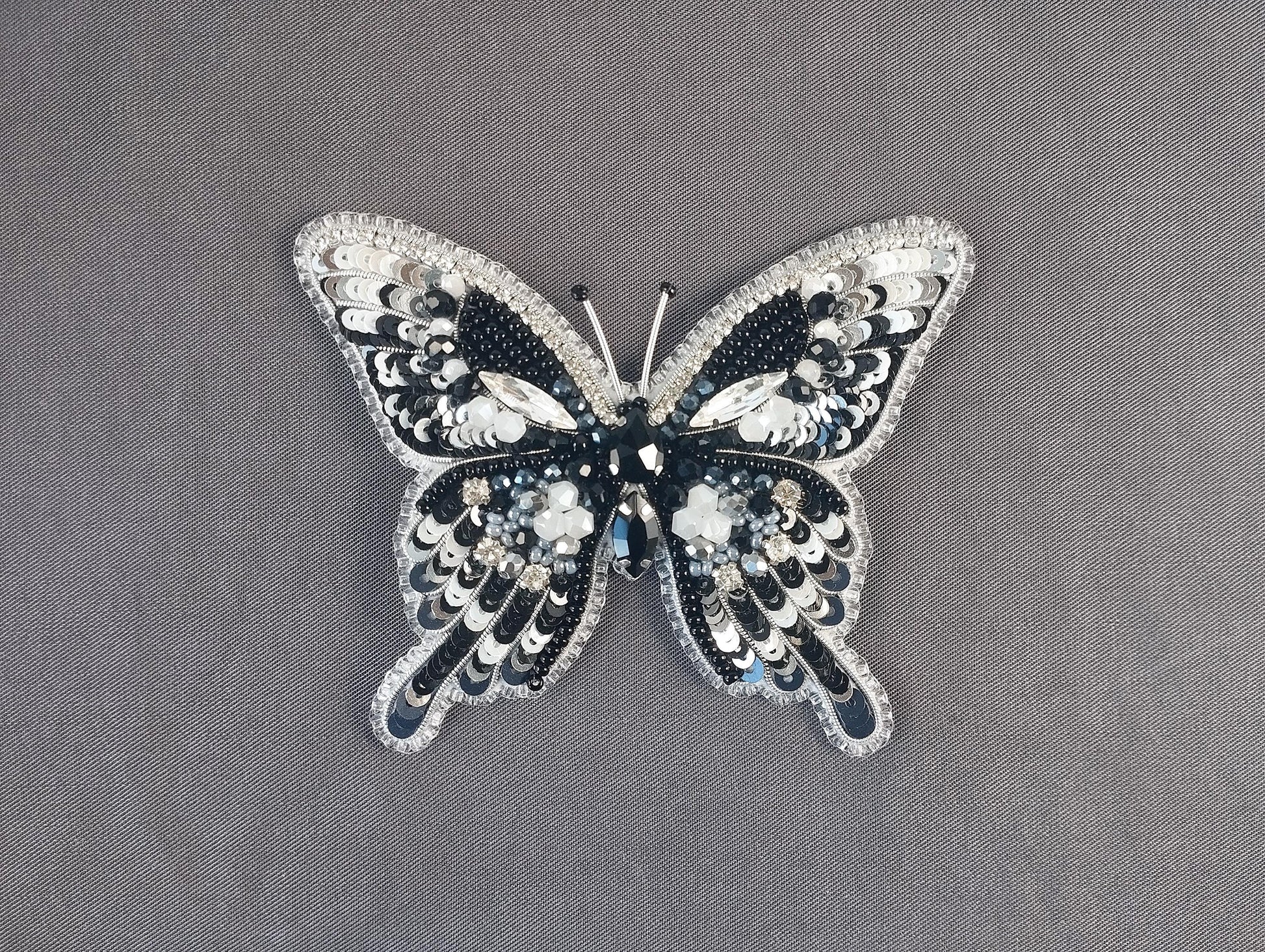 a black and white butterfly brooch sitting on top of a table