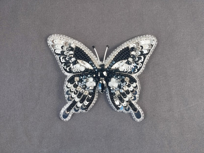 a black and white butterfly brooch sitting on top of a table