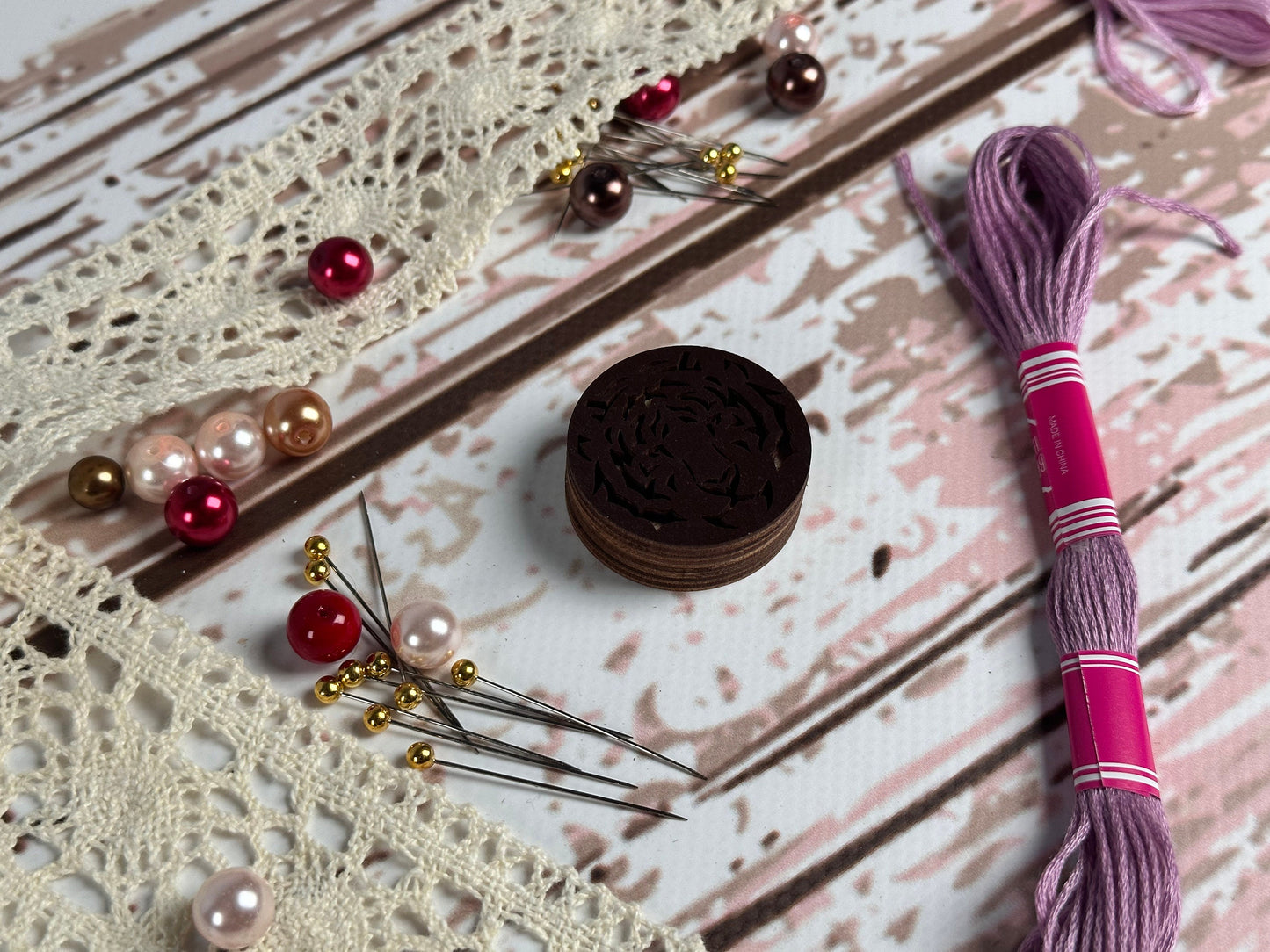 a piece of lace next to a pair of scissors and beads