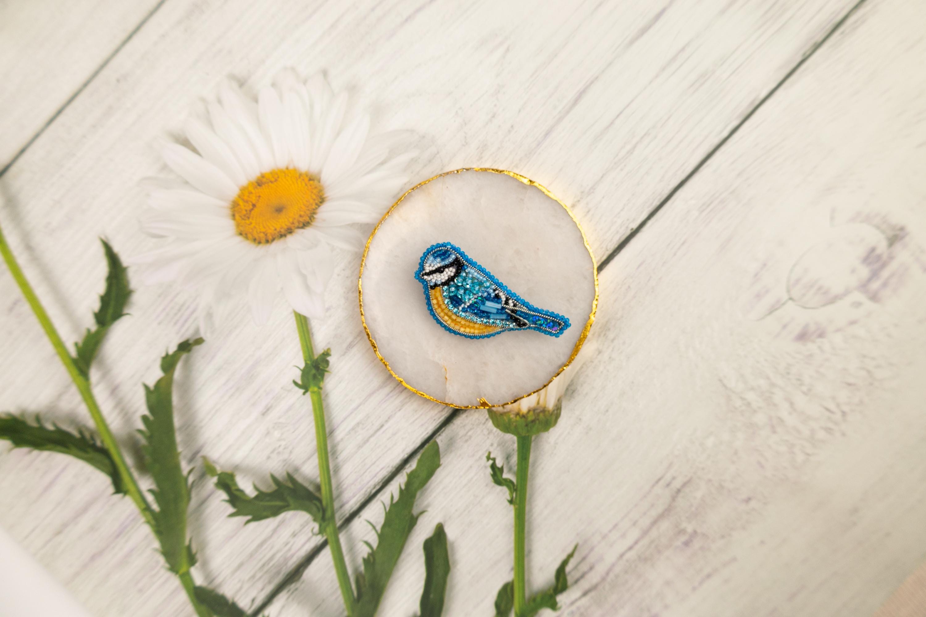 a blue bird sitting on top of a white flower