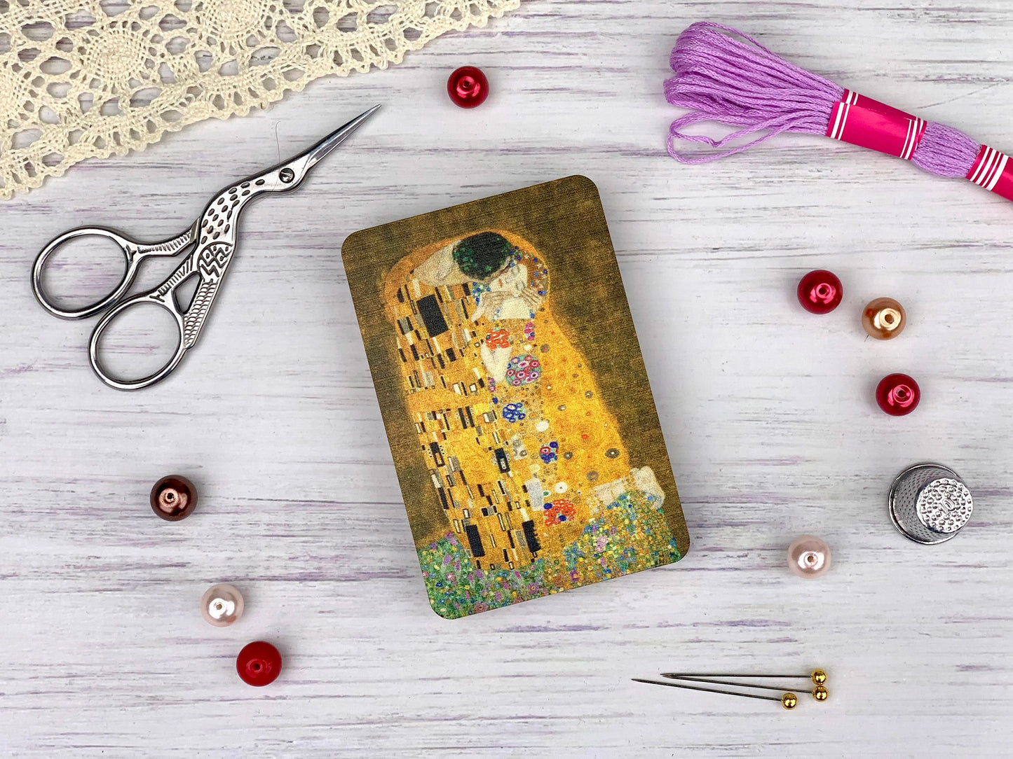 a pair of scissors, a pair of thread, and a picture of the kiss