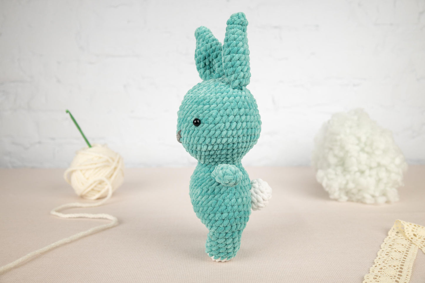 a crocheted bunny rabbit next to a ball of yarn