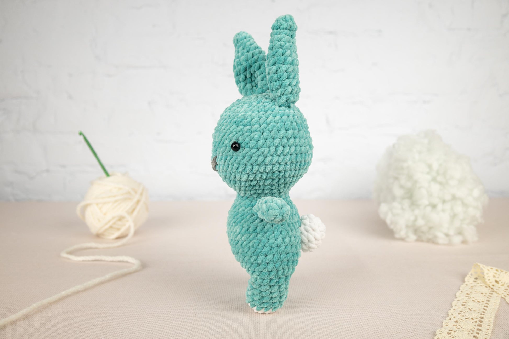 a crocheted bunny rabbit next to a ball of yarn