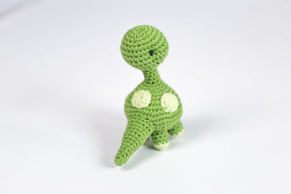 a crocheted toy of a green dinosaur